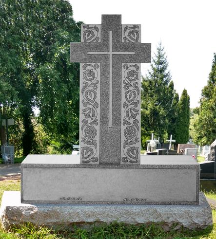 Three bar Orthodox cross monument with carved floral embroidery panels down both arms and the shaft, standing in a cemetery