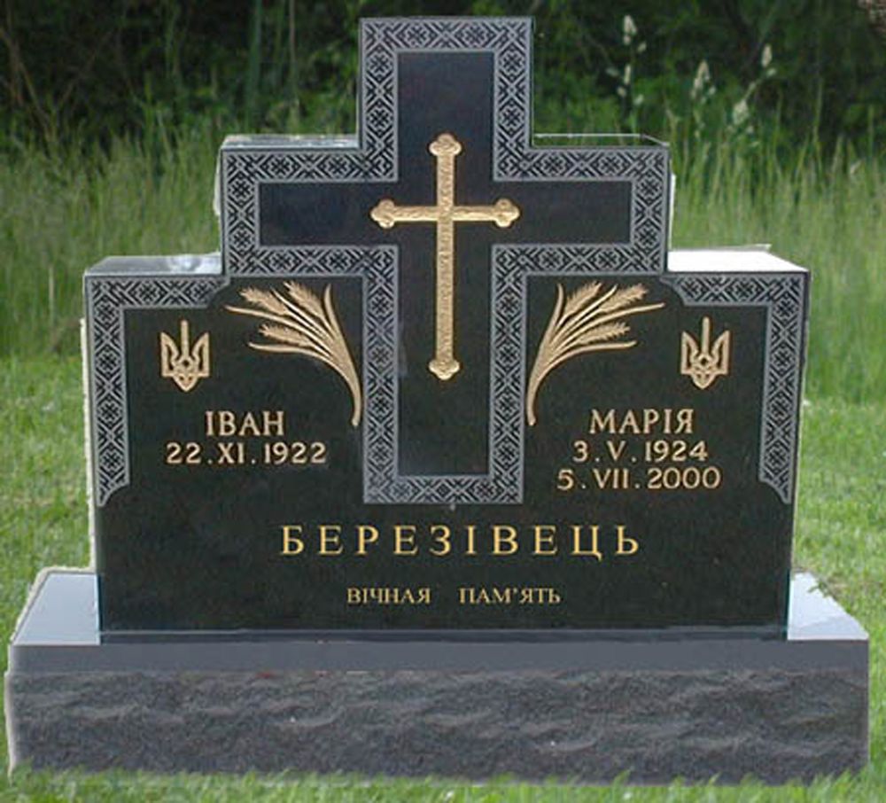 Black granite double monument carved with an embroidery pattern border, two tryzub emblems, gilded wheat sheaves and a Cyrillic inscription